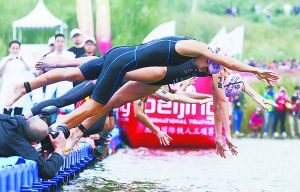 北京国际铁人三项赛选手在园博湖鱼跃入水